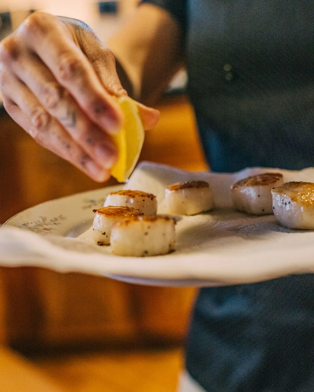 Lemon squeezed over seared scallops