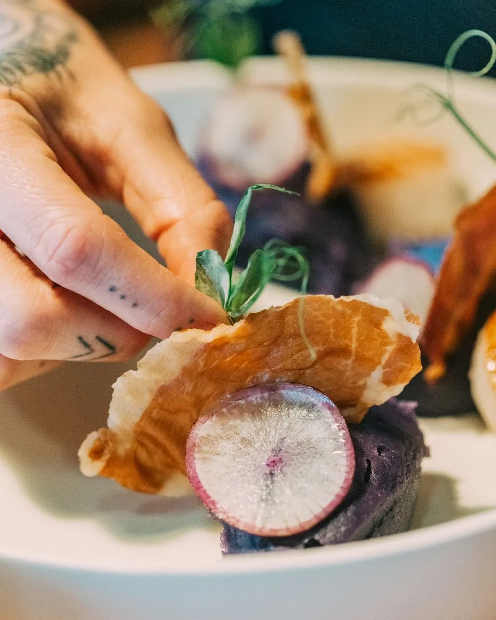 Placing a pea shoot on a scallop plate